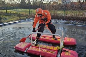 Feuerwehrmann im Überlebensanzug auf dem Eisretter