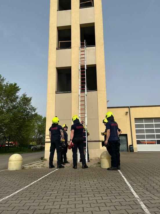 Feuerwehrmänner üben am Schlauchturm mit Leitern