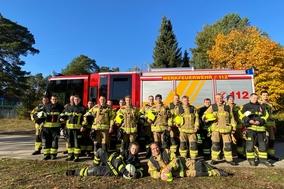 Gruppenbild vor einem Fahrzeug der Feuerwehr