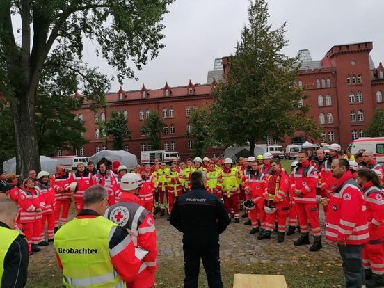 Viele Personen in Rettungsdienstkleidung sthen auf einem Platz