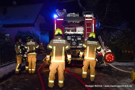 Löschfahrzeug mit Feuerwehrmännern im Dunkeln.