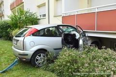 Auto eingeklemmt unter Balkon mit Leine am Heck