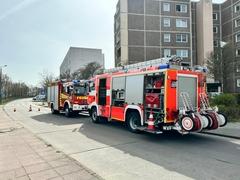 Zwei Feuerwehrfahrzeuge vor einem Haus an der Straße