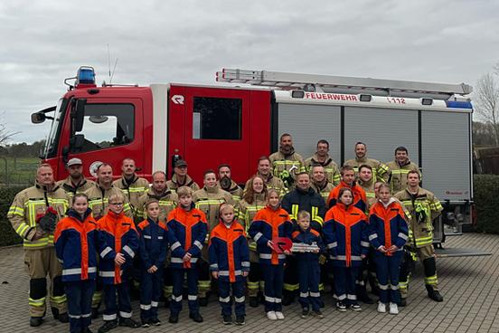 Gruppenbild der Kameraden vor dem Löschfahrzeug