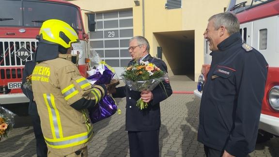 Mitarbeiter nimmt Abschiedsgeschenke entgegen