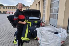 Feuerwehrmann beim Einsortieren der Feuerwehrkleidung ins Auto