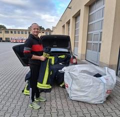 Feuerwehrmann beim Einsortieren der Feuerwehrkleidung ins Auto