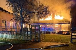 Brennender Dachstuhl, vorn liegen Schläuche