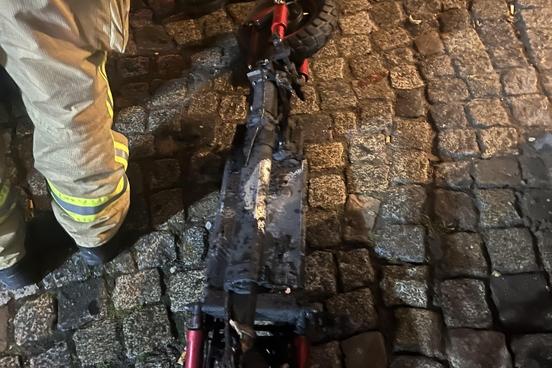Verbrtannter E-Scooter auf der Straße