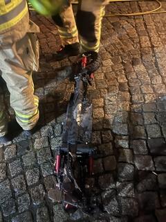 Verbrtannter E-Scooter auf der Straße