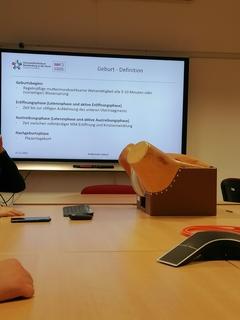 im Vordergrund das Geburtsphantom im Hintergrund eine Power Point Folie