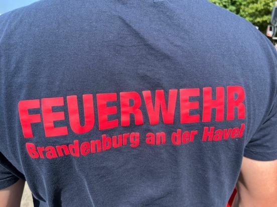 Feuerwehrmann von hinten. Aufschrift Feuerwehr Brandenburg an der Havel ist zu lesen.