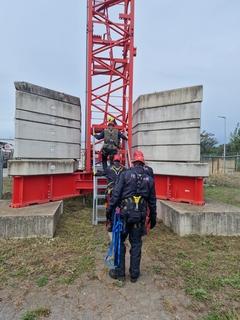 Männer stehen unten am Baukran