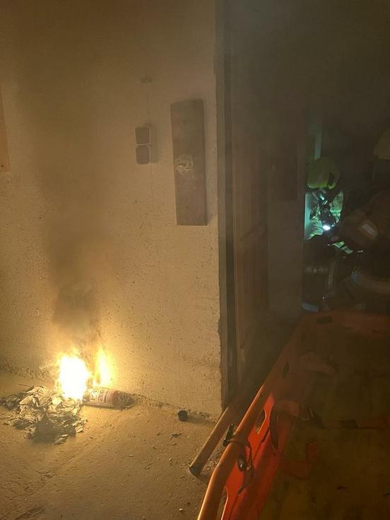 Flammen im Kellergang im Hintergrund ein Feuerwehrmann