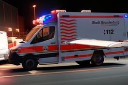 Krankenwagen im dunkeln auf einer Straße. Der Krankenwagen hat Tragflächen an der Seite