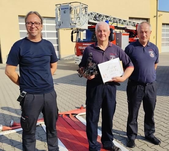 3 Feuerwehrmänner vor der Drehleiter