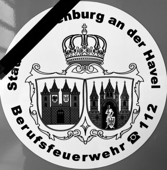 Logo der Feuerwehr in schwarz-weiß, mit Trauerflor