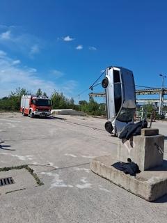 Auto steht hochkant, im Hintergrund ein Feuerwehrfahrzeug