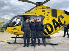 3 Frauen vor eine Rettungshubschrauber im ADAC Design