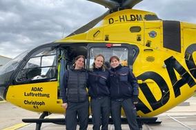 3 Frauen vor eine Rettungshubschrauber im ADAC Design