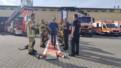 Mitarbeiter läuft unter Applaus über den roten Schlauchteppich