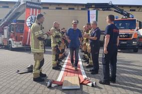 Mitarbeiter läuft unter Applaus über den roten Schlauchteppich