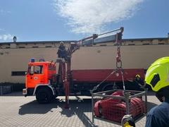 Kran der Feuerwehr hebt Korb mit Schläuche