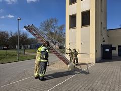 Feuerwehrmänner mit Leitern am Schlauchturm
