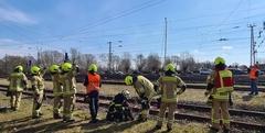 Feuerwehrmänner stehen an Bahngleisen und üben Bahnerden