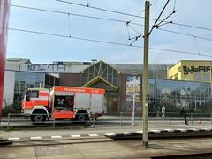 Ein Feuerwehrfahrzeug an der Straße. Schienen sind davor zu sehen.