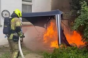 Feuerwehrmann löscht brennenden Pavillon