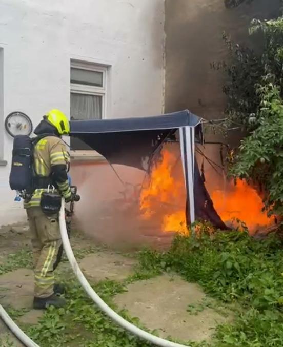 Feuerwehrmann löscht brennenden Pavillon