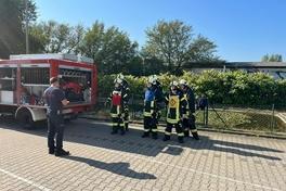 Ausbilder der Feuerwehr und Lehrgangsteilnehmer draußen vor dem Löschteich.