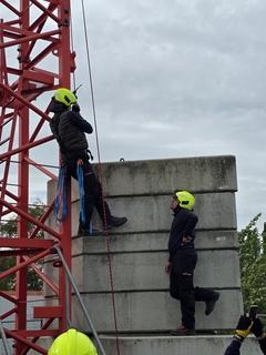 Ein Mann beginnt sich am Baukran zu sichern