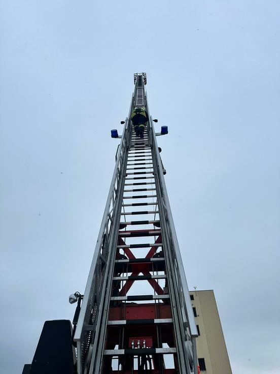Feuerwehrmann klettert die Drehleiter empor