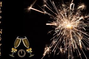 Feuerwekr am Himmel mit Schriftzug an der Seite Happy New Year und Sektgläser