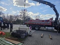 Betonblöcke am Kran und Feuerwehrmänner stehen daneben