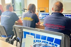 3 Mitarbeiter im Schulungsraum von hinten