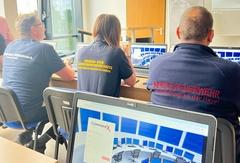 3 Mitarbeiter im Schulungsraum von hinten