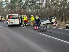 Verkehrsunfall mit Kleinbus und PKW, der PKW liegt im Hintergrund auf dem Dach