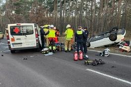 Verkehrsunfall mit Kleinbus und PKW, der PKW liegt im Hintergrund auf dem Dach