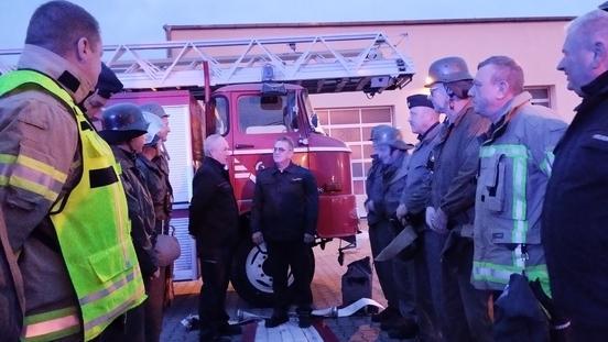 Feuerwehrmänner stehen vor einem Feuerwehrfahrzeug