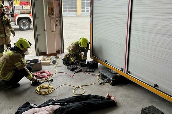 2 Feuerwehrmänner arbeiten am hydraulischem Rettungsgerät am Container.
