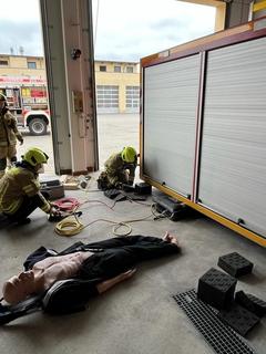 2 Feuerwehrmänner arbeiten am hydraulischem Rettungsgerät am Container.