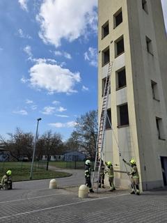 Feuerwehrmänner mit Leitern am Schlauchturm