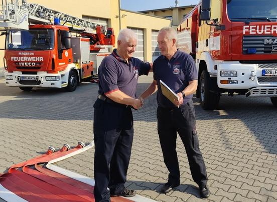 Übergabe Geschenk an Feuerwehrmann