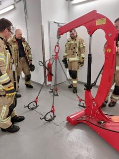 Feuerwehrmänner stehen am Flurplattenhebegerät