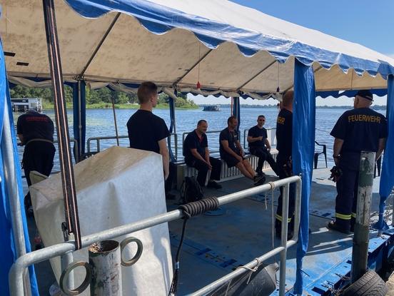 Feuerwehrmänner sitzen auf einem großen Boot