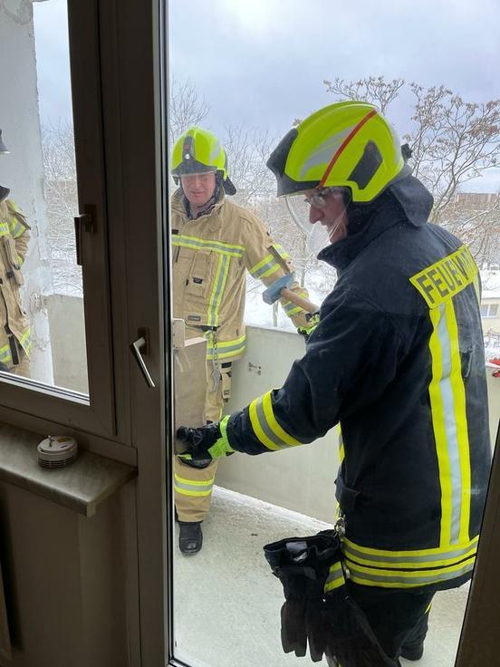 Feuerwehrmänner öffnen Terrassenfenster von außen