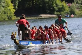 Drachenboot auf dem Wasser mit Besatzung